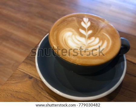 Cup of coffee with latte art and slight milk foam in vintage loft vibes. Selective focus. Cafe, coffee, barista concept.