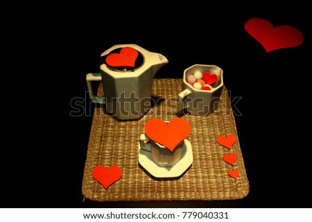 Coffe glasses, with red hearts on rustic tablecloth and black background