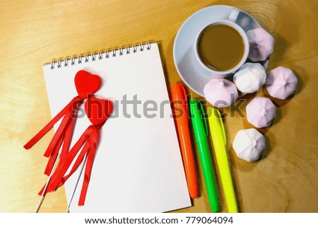 symbols of the heart on a notepad. coffee and biscuits. on a wooden board. view from above.