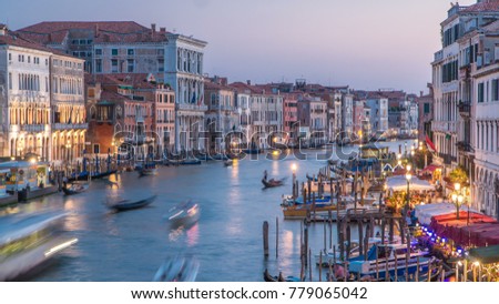 Grand Canal in Venice, Italy day to night transition timelapse. View on gondolas and city lights from Rialto Bridge. Beautiful and romantic Italian city on water.