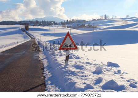 Road sign in a snowy, hilly winter landscape, mountains in the background, Allgau, Bavaria