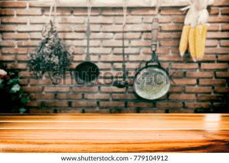 Empty wooden table for present product on vintage kitchen utensils blur background with bokeh image.