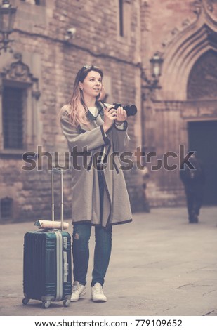 Young happy cheerful woman looking curious and taking the pictures outdoors