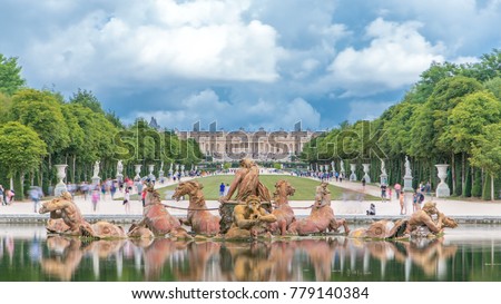 Apollo fountain in the Versailles Palace park, Ile de France. Royal Palace on background with reflection on water. Crowd of tourists at summer day Royalty-Free Stock Photo #779140384