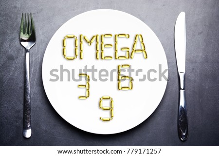 nutritional supplement of omega 3, omega 6 or omega 9 from yellow fish oil capsules on plate Royalty-Free Stock Photo #779171257