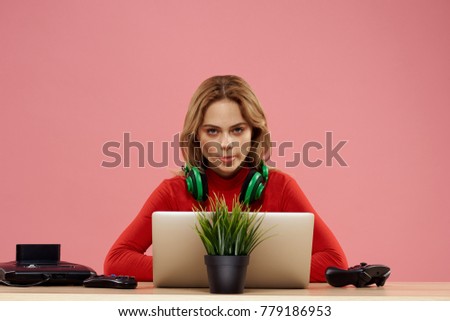    woman with headphones sitting at table with laptop                            