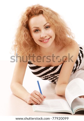 A young girl lying on the floor and studying