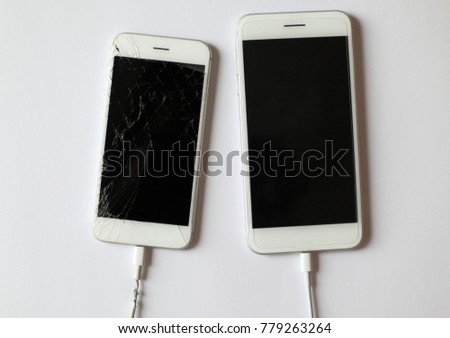 Concept of connectivity and communication. Old and new smartphone charge battery with new and torn wire, selective focus, top view