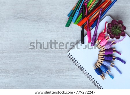 Creative design concept with colorful embroidery thread and colorful pen and empty page book on white wood workplace background