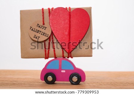 happy valentines day - inscription on label card. wooden red car toy transports
 gift box wrapped in craft paper. Express your love through handmade. big red heart hang on red thread