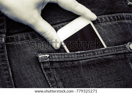 The hand pulls the phone out of the jeans pocket. Theft on vacation.