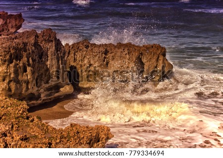 waves crashing against a  textured rocky coastline