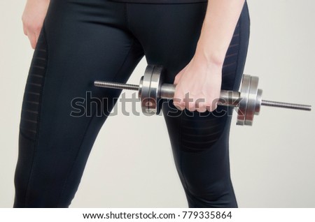 the girl is holding a dumbbell in her hand
