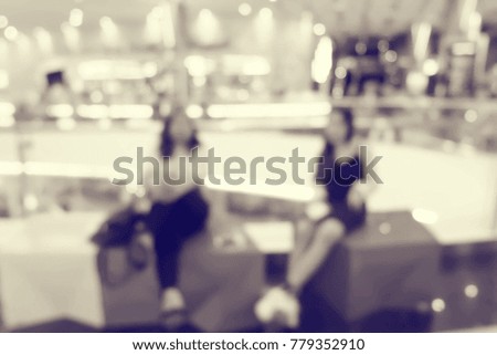Blurred image of people in shopping mall with bokeh .