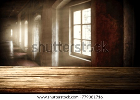 Wooden table of free space and background of few windows 