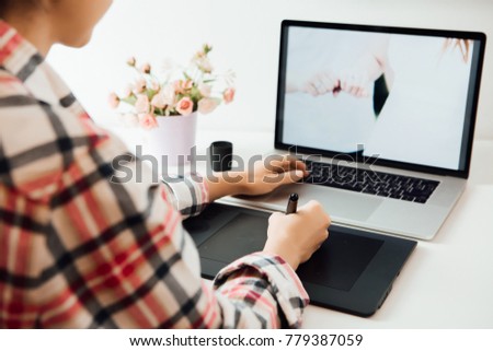 woman retouching on computer laptop using digital tablet and stylus pen