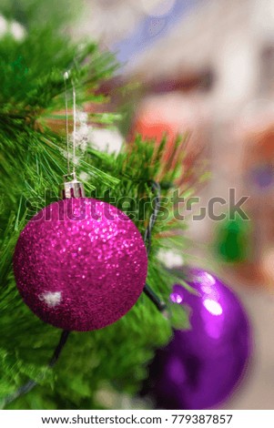 Lilac Christmas balls on a snow-covered tree branch. christmas tree background. red toy with frost and snowflakes.