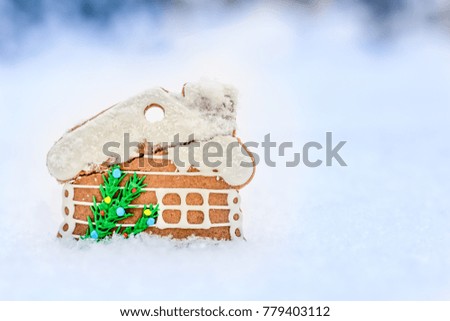 Gingerbread house on winter outdoor background, Christmas greeting card, snow and smoke effect.
