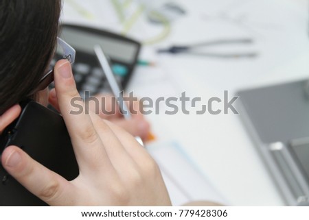 Photo of the Attractive business woman use smart phone and sitting at her worktable with documents and electronic devices