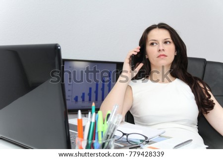 Photo of the Attractive business woman use smart phone and sitting at her worktable with documents and electronic devices