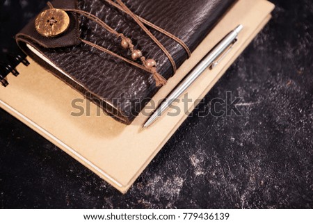 Top view on aged retro notebook with leather cover on dark wooden backgorund