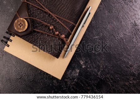 Top view on aged retro notebook with leather cover on dark wooden backgorund