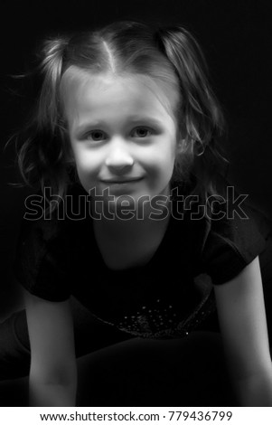 Beautiful little girl on a black background. Studio photography