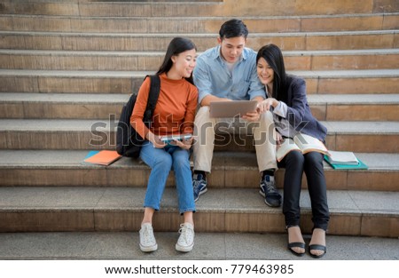 Group of asian students reading books in the big city street