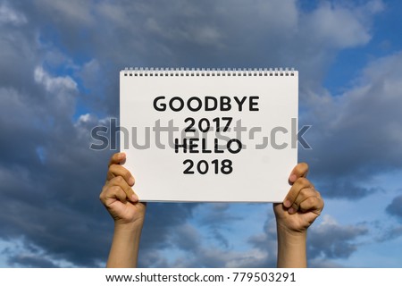 Hands holding a placard paper with word - Goodbye 2017 Hello 2018.