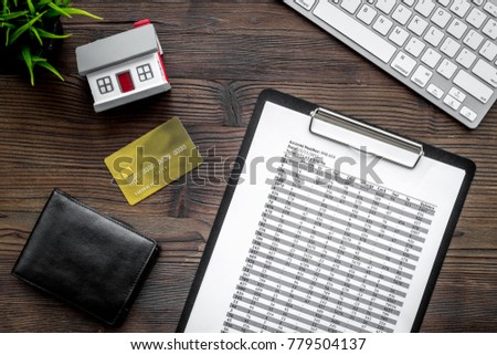 Pay the mortgage. Payment schedule near bank card and wallet on dark wooden background top view