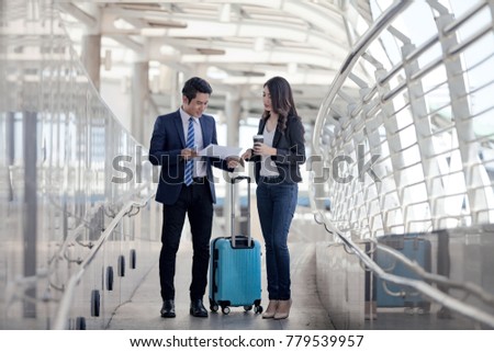 male businessman holds a briefcase with a businesswoman lugging while preparing to travel abroad at Outside Office,  Success and Happiness Team Concept. Royalty-Free Stock Photo #779539957
