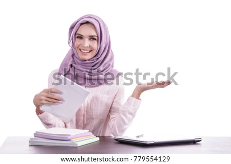 portrait of beautiful college student wearing hijab studying while presenting copy space isolated on white background
