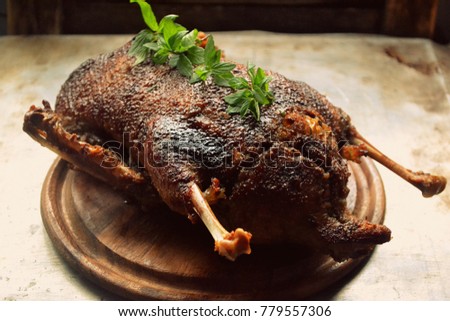 Appetizing and delicious duck with a golden crust with green mint on a gray metallic background to the festive table.