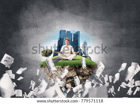 Man in white clothing keeping eyes closed and looking concentrated while meditating on island in the air among flying papers with gray dark wall on background. 3D rendering.