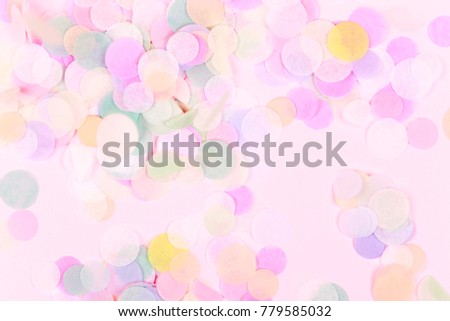 Vibrant confetti on pastel pink background. Festive backdrop for your design.