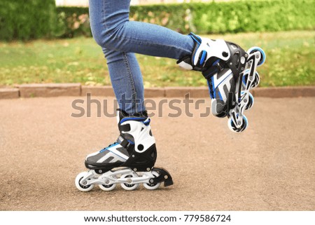 Legs of young woman rollerskating outdoors