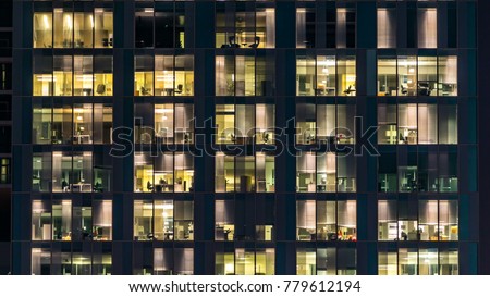 Blinking light in window of the multi-storey building of glass and steel lighting and people within timelapse close up view. Dubai, UAE Royalty-Free Stock Photo #779612194