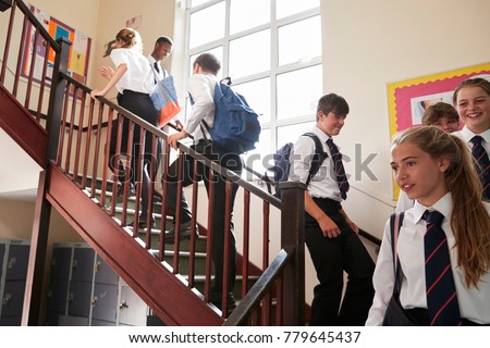 Group Of Teenage Students In Uniform Walking Between Classrooms Royalty-Free Stock Photo #779645437