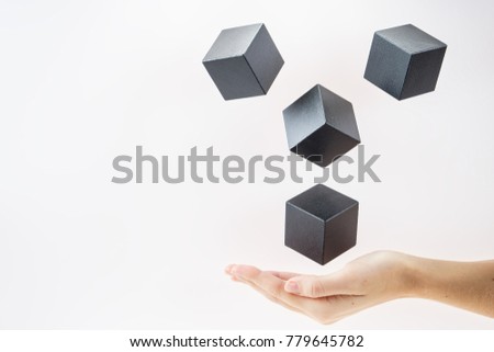 Black wooden cubes are floating on open woman hand.  Concept of creative, logical thinking. Abstract background with cubes with copy space. Shape floating.