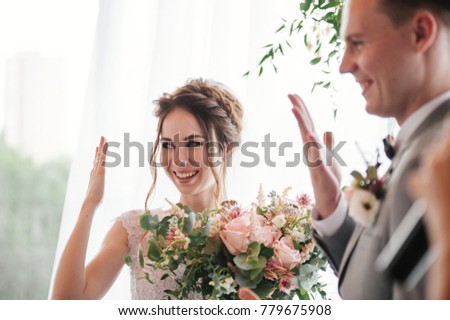 Wedding ceremony. Portrait of a bride in a pink dress. The groom in a gray suit. Exchange of the wedding rings.