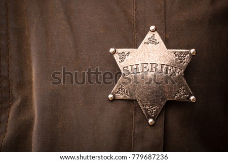 Close up of sheriff badge when on his coat duster Royalty-Free Stock Photo #779687236