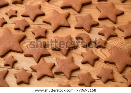 Christmas gingerbread cakes in shape of stars on rustic wooden table.