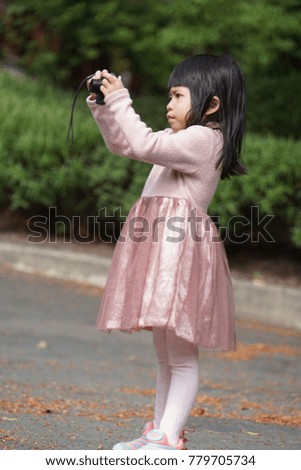 Asian cute girl holding a camera,try to take a photo. Young Photographer.