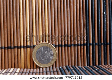 One euro coin lie on wooden bamboo table Denomination is one euro