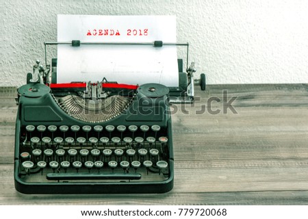 Typewriter with white paper page on wooden desk. Business concept. Sample text AGENDA 2018. vintage style picture