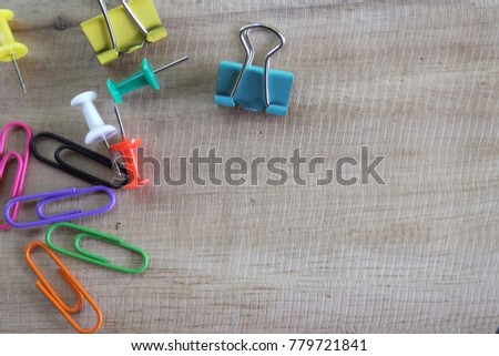 set of push pins with paper clip on the wooden background, space 