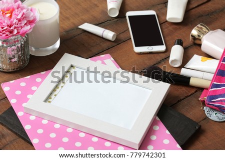 Busy desk of a fashion woman. Makeup objects scattered.