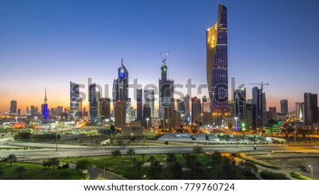 Skyline with Skyscrapers day to night transition timelapse in Kuwait City downtown illuminated at dusk. Kuwait City, Middle East. View from rooftop Royalty-Free Stock Photo #779760724