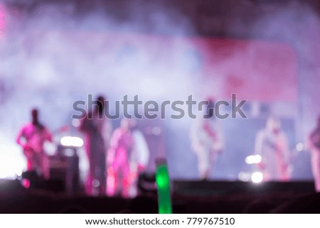 Blurred picture of music bands during performing on stage while lighting show effect of smoke can be use as background of content about concert stage show music festival or celebration event.