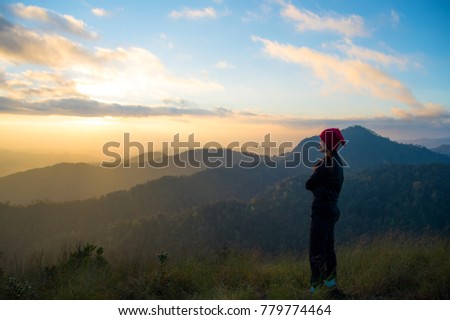 Woman tourism hiking vacation and travel. Tourist woman in camping site standing and enjoying mountains landscape view of sunset, sunrise at winter mountain in Chiangmai, Thailand. Royalty-Free Stock Photo #779774464